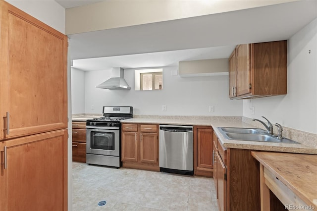 kitchen with stainless steel appliances, sink, and wall chimney exhaust hood