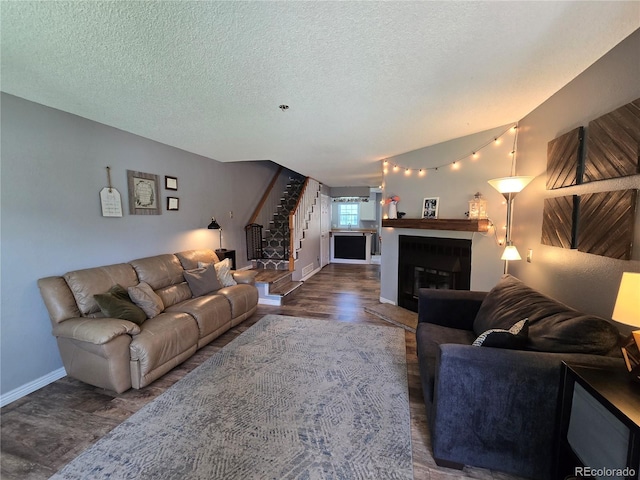 14232 E Hawaii Cir Unit A, Aurora, CO 80012 - living area with stairs, a textured ceiling, a glass covered fireplace, and wood finished floors