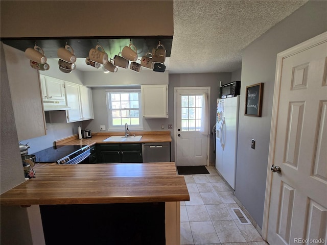 14232 E Hawaii Cir Unit A, Aurora, CO 80012 - kitchen with butcher block countertops, under cabinet range hood, appliances with stainless steel finishes, white cabinets, and a textured ceiling