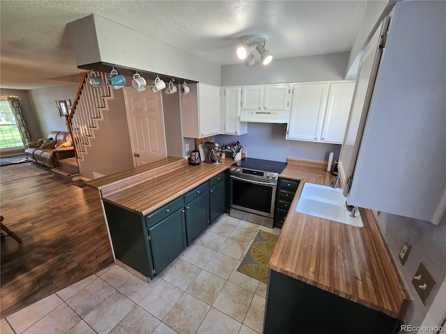 14232 E Hawaii Cir Unit A, Aurora, CO 80012 - kitchen featuring under cabinet range hood, electric range, blue cabinetry, a peninsula, and open floor plan