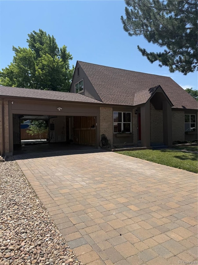 16796 E Union Ave, Aurora, CO 80015 - view of front of home featuring decorative driveway, a shingled roof, an attached garage, and brick siding