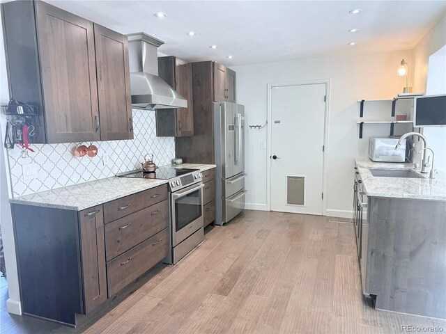 16796 E Union Ave, Aurora, CO 80015 - kitchen with electric range, wall chimney exhaust hood, freestanding refrigerator, light wood-type flooring, and backsplash