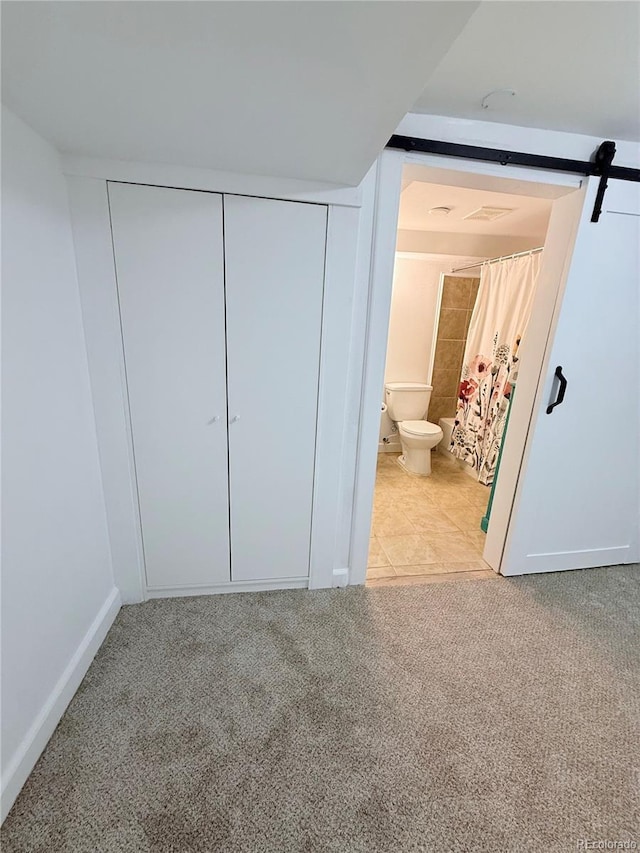 16796 E Union Ave, Aurora, CO 80015 - unfurnished bedroom featuring light colored carpet, a closet, a barn door, and ensuite bathroom