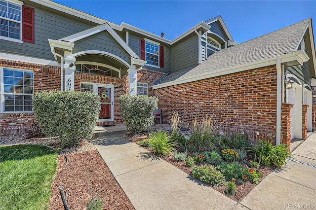 property entrance with brick siding and roof with shingles