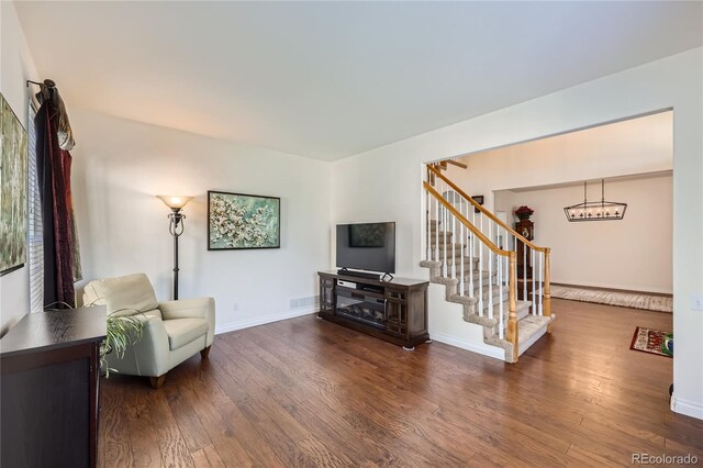 sitting room with visible vents, stairs, baseboards, and wood finished floors