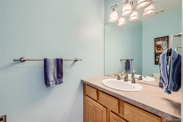 bathroom featuring vanity, visible vents, and an inviting chandelier