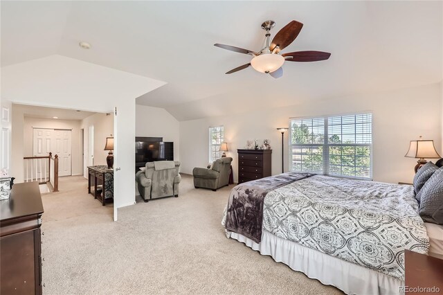 carpeted bedroom with vaulted ceiling and a ceiling fan