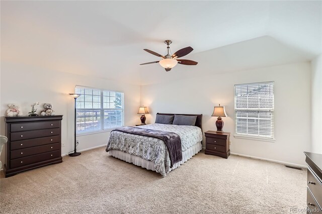 carpeted bedroom with baseboards, vaulted ceiling, visible vents, and ceiling fan