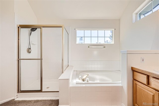 bathroom featuring a garden tub, a shower stall, and vanity