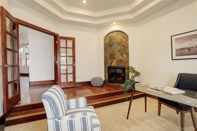 office space featuring a raised ceiling, french doors, recessed lighting, and a tile fireplace