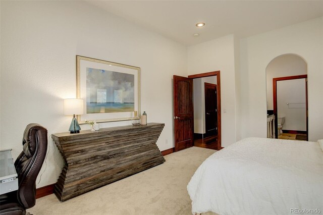 bedroom featuring arched walkways, ensuite bathroom, carpet flooring, and recessed lighting