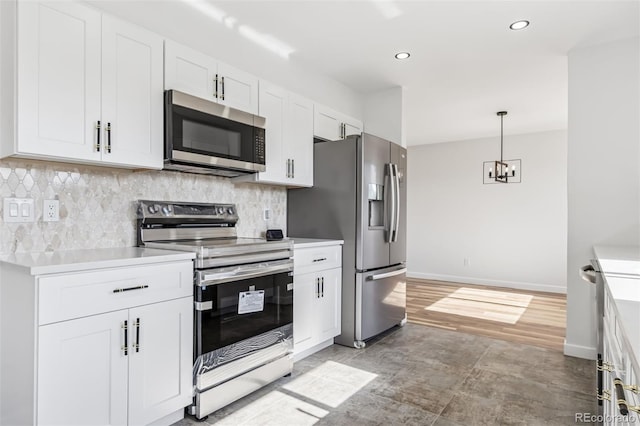 7351 S Marion St, Centennial, CO 80122 - kitchen featuring stainless steel appliances, white cabinetry, light countertops, a chandelier, and backsplash