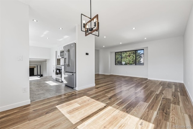 7351 S Marion St, Centennial, CO 80122 - unfurnished living room with wood finished floors, recessed lighting, a chandelier, and a fireplace