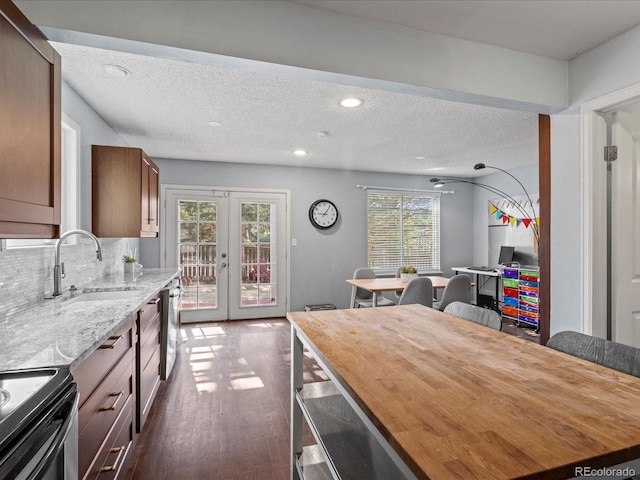 966 Cherry Blossom Ct, Highlands Ranch, CO 80126 - kitchen featuring dark wood-style flooring, stainless steel appliances, french doors, light stone counters, and backsplash