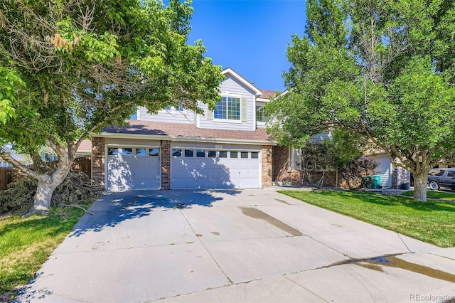 1730 Pear Ct, Brighton, CO 80601 - view of property hidden behind natural elements with concrete driveway, a garage, brick siding, and a front yard