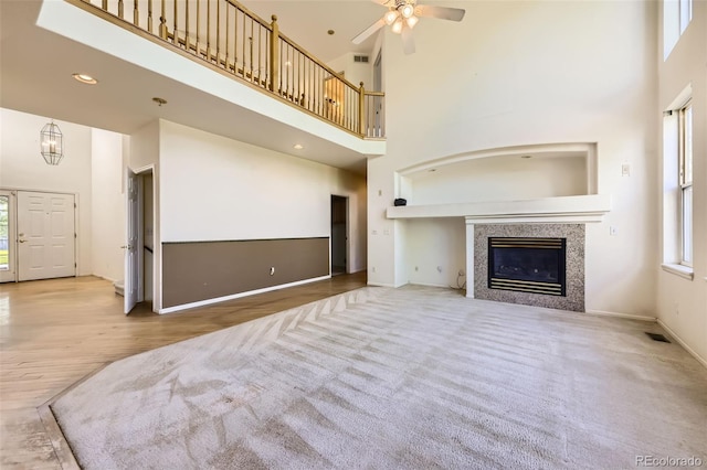 1730 Pear Ct, Brighton, CO 80601 - unfurnished living room featuring a towering ceiling, ceiling fan, a tile fireplace, and carpet floors