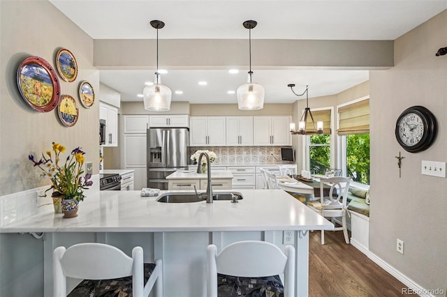 775 Poppywood Dr, Highlands Ranch, CO 80126 - kitchen featuring stainless steel refrigerator with ice dispenser, a peninsula, dark wood-style flooring, light countertops, and backsplash