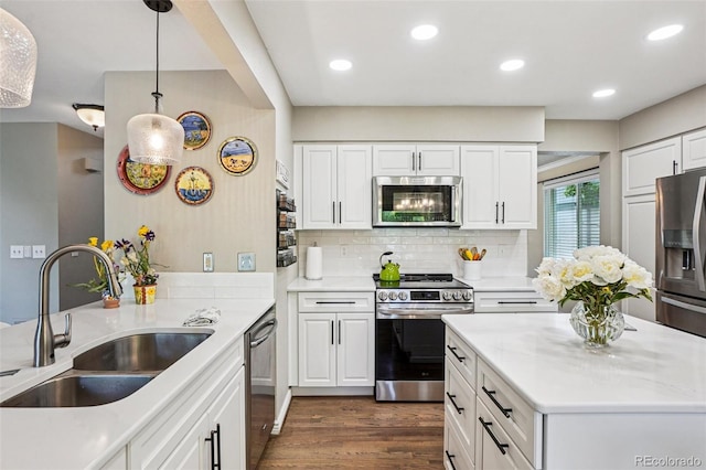 775 Poppywood Dr, Highlands Ranch, CO 80126 - kitchen featuring appliances with stainless steel finishes, dark wood finished floors, tasteful backsplash, white cabinets, and recessed lighting