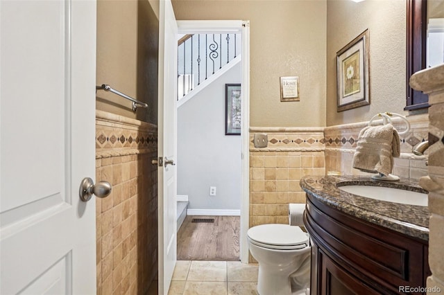 775 Poppywood Dr, Highlands Ranch, CO 80126 - bathroom featuring tile walls, vanity, and a wainscoted wall