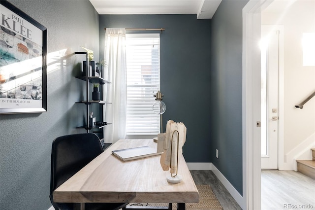 office area with wood finished floors, baseboards, and a textured wall