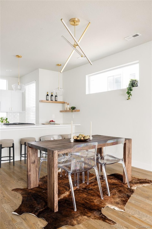 dining room with wood finished floors and visible vents