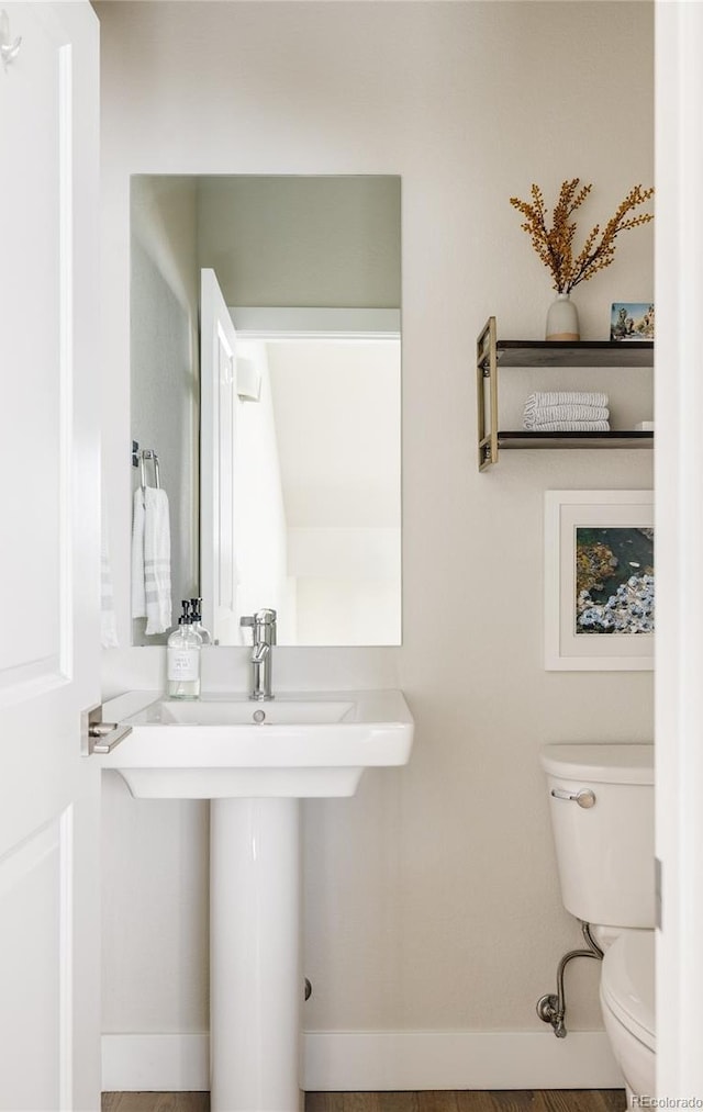 bathroom featuring baseboards and toilet