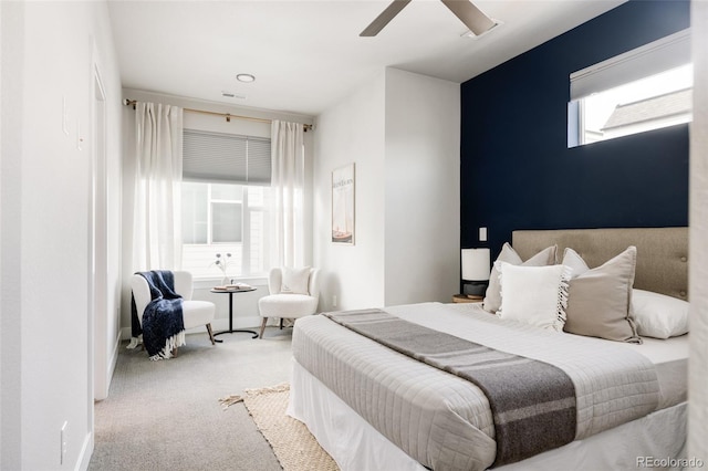 carpeted bedroom with visible vents, multiple windows, baseboards, and a ceiling fan