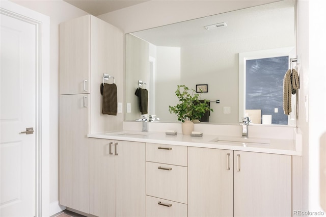 bathroom featuring double vanity, visible vents, and a sink