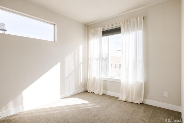 carpeted spare room featuring baseboards