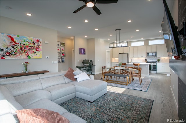 10018 E 62nd Ave, Denver, CO 80238 - living area featuring wood finished floors, ceiling fan, recessed lighting, and a chandelier