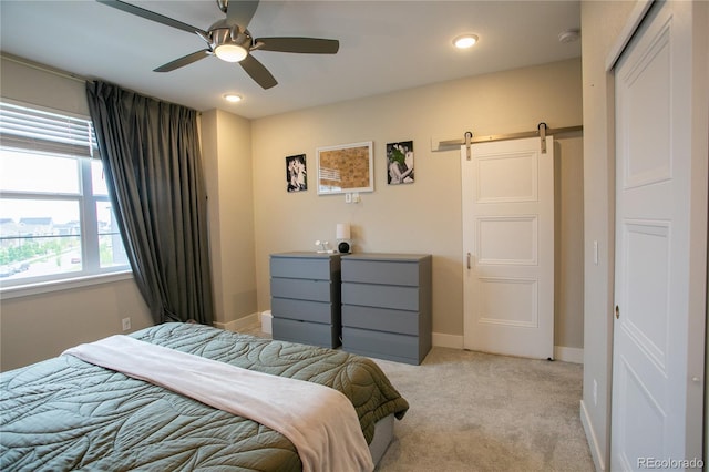 10018 E 62nd Ave, Denver, CO 80238 - bedroom featuring a barn door, light colored carpet, recessed lighting, baseboards, and ceiling fan