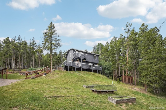 150 Cedar Rd, Evergreen, CO 80439 - view of green lawn featuring a garden, a wooden deck, and a view of trees