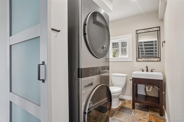 150 Cedar Rd, Evergreen, CO 80439 - bathroom featuring stacked washer / drying machine, stone finish floors, and a shower with door