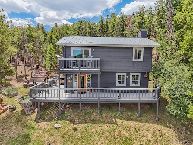 150 Cedar Rd, Evergreen, CO 80439 - back of property with a standing seam roof, a chimney, a balcony, a metal roof, and a deck