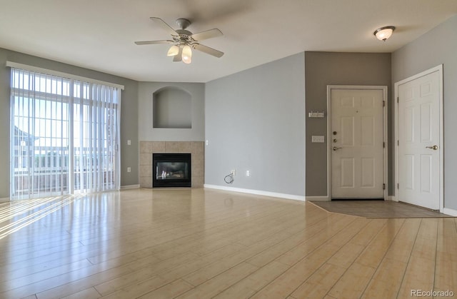 7440 S Blackhawk St Unit 12-204, Englewood, CO 80112 - unfurnished living room featuring a ceiling fan, wood finished floors, baseboards, and a tile fireplace