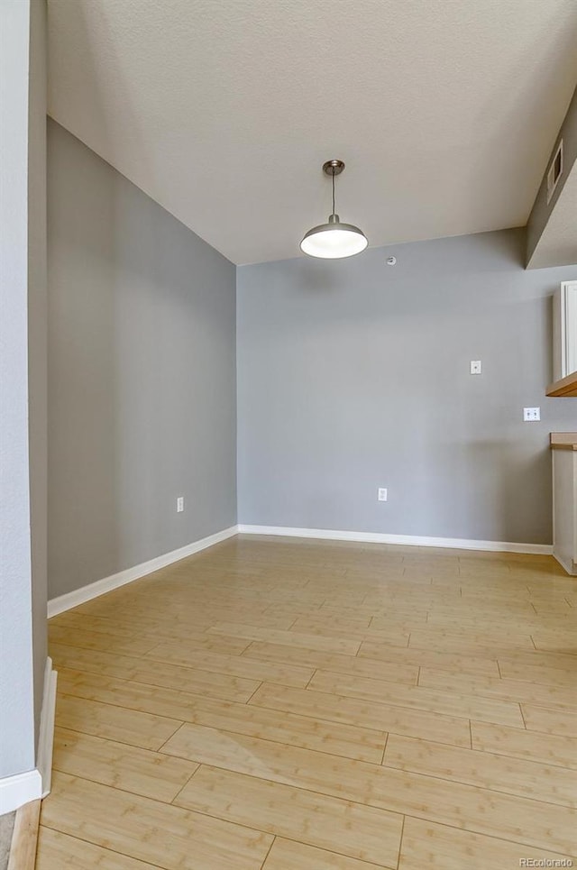 7440 S Blackhawk St Unit 12-204, Englewood, CO 80112 - empty room featuring light wood-style floors, baseboards, and a textured ceiling