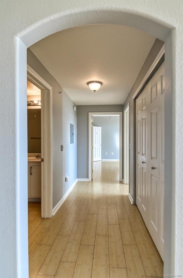 7440 S Blackhawk St Unit 12-204, Englewood, CO 80112 - hallway featuring baseboards, a sink, and light wood finished floors
