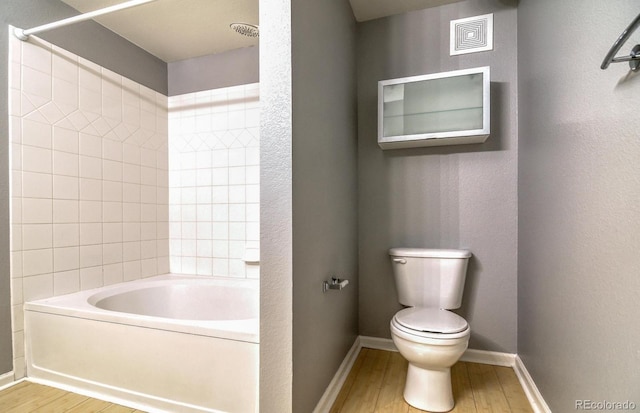 7440 S Blackhawk St Unit 12-204, Englewood, CO 80112 - bathroom with wood finished floors, toilet, baseboards, and bathing tub / shower combination