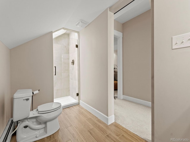 bathroom featuring walk in shower, toilet, and a baseboard heating unit