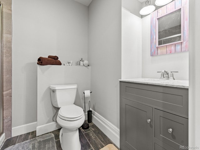 bathroom with vanity, toilet, and a shower with shower door