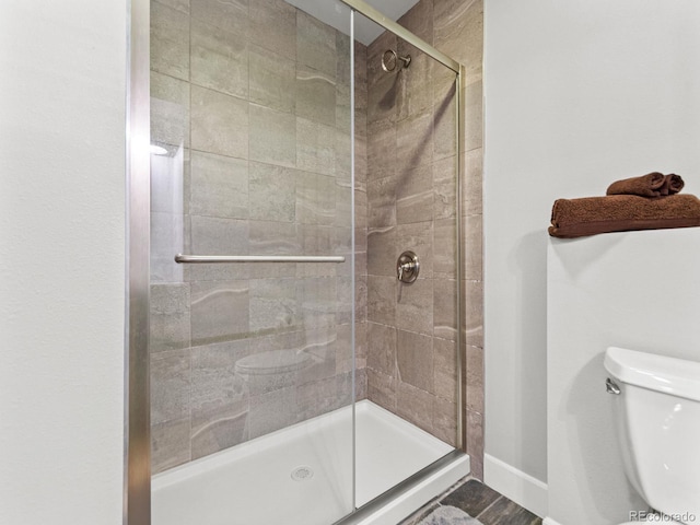 bathroom featuring toilet and an enclosed shower