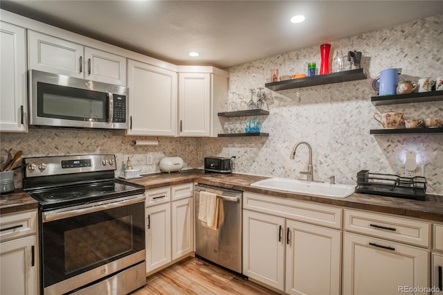 1842 Canyon Blvd Unit 105, Boulder, CO 80302 - kitchen with stainless steel appliances, butcher block counters, open shelves, a sink, and backsplash