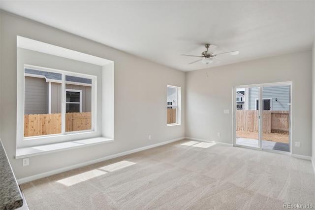 unfurnished room with light colored carpet and ceiling fan