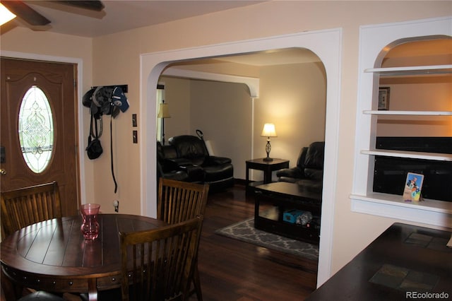 dining space with arched walkways, wood finished floors, and ceiling fan
