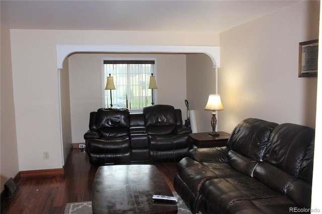 living area featuring hardwood / wood-style floors, arched walkways, and baseboards