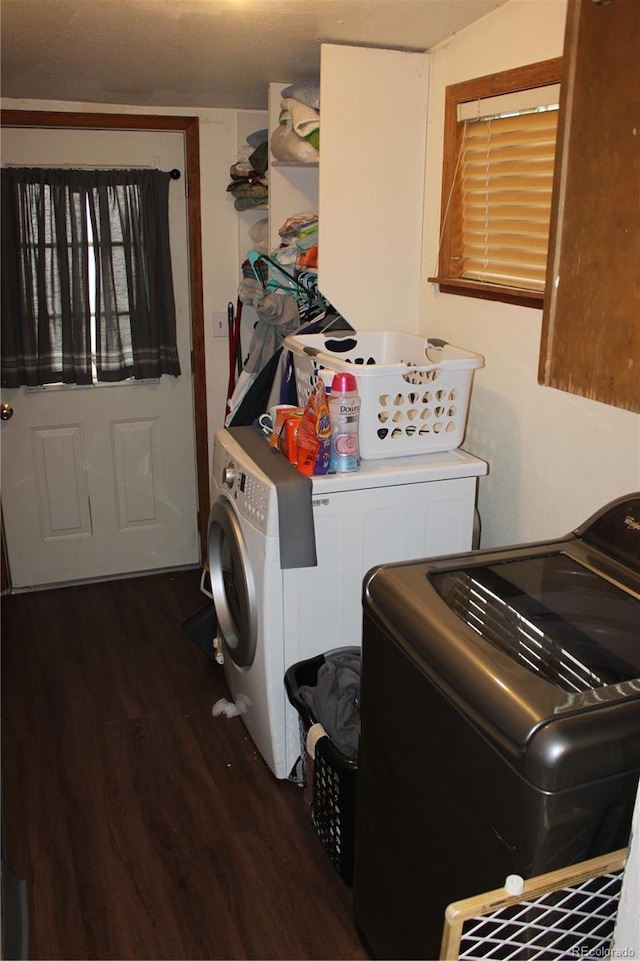 clothes washing area featuring washing machine and dryer and wood finished floors