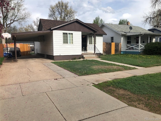 view of front of property with concrete driveway, an attached carport, a shingled roof, and covered porch