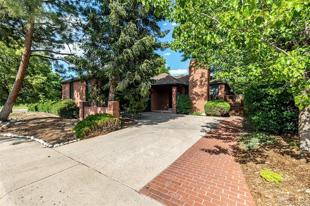 5401 E Dakota Ave Unit 22, Denver, CO 80246 - view of front of house with driveway, a chimney, and brick siding