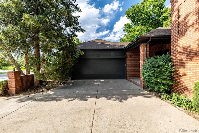 5401 E Dakota Ave Unit 22, Denver, CO 80246 - view of home's exterior with brick siding, driveway, a garage, and a shingled roof