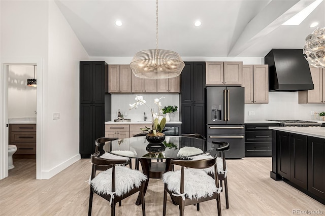 5401 E Dakota Ave Unit 22, Denver, CO 80246 - kitchen with appliances with stainless steel finishes, custom range hood, tasteful backsplash, a chandelier, and light wood finished floors